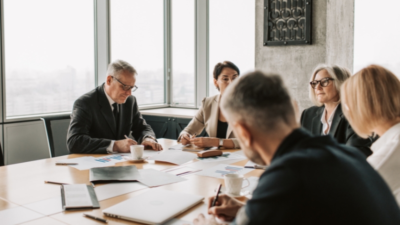 Executives review reports and share updates during a level 10 meeting