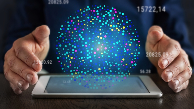 Hands holding a tablet with a digital sphere of colorful data points representing big data visualization