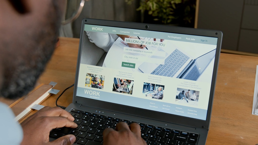 Professional browsing an online job platform and searching through digital workplace tools on a laptop