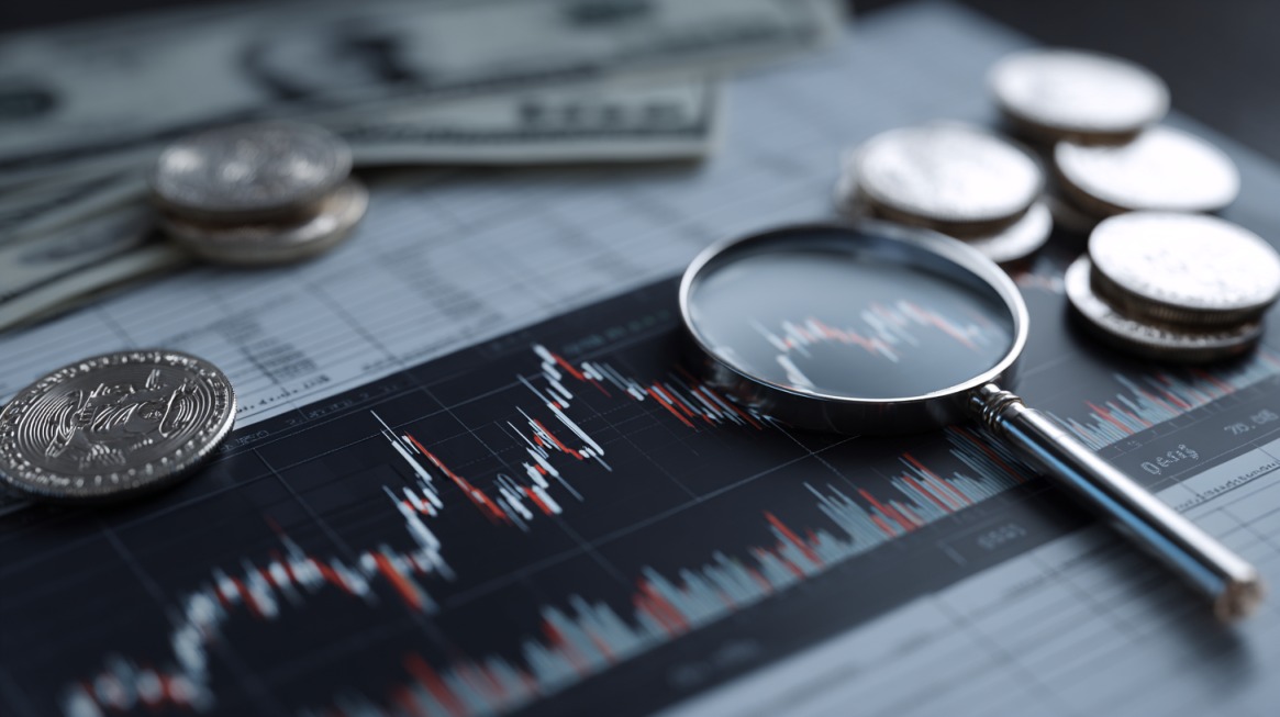 Magnifying glass over financial charts with coins and dollar bills